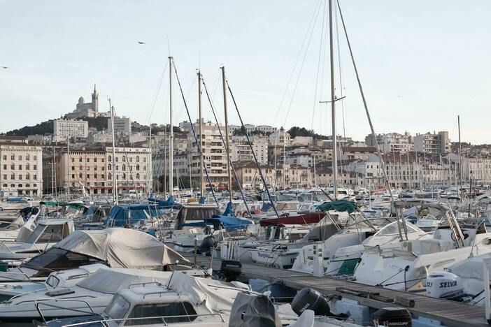 Vieux Port - Port de plaisance (comportant de nombreux bateaux) 
            au premier plan, avec vue sur la basilique Notre-Dame-de-la-Garde au second plan