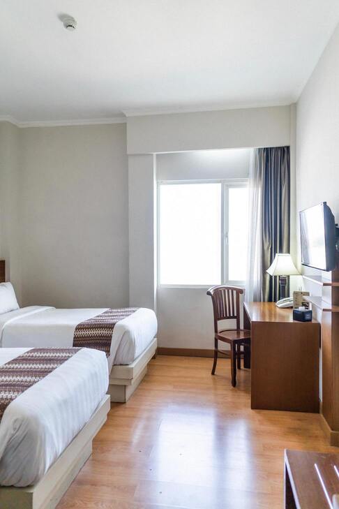 Hôtel chez Amina - Chambre lumineuse avec 2 lits séparés, équipée d'un téléviseur, d'un téléphone et d'un bureau