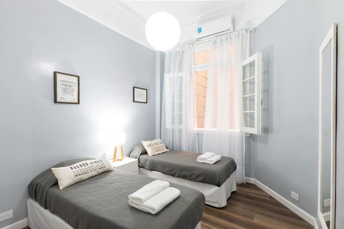 Hôtel du port - Chambre avec 2 lits séparés (avec une table de chevet au milieu), et équipée d'une climatisation, 
                et d'un miroir face aux lits